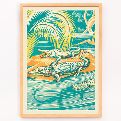 A Jungle Picnic Pl.03 Crocodile by Clifford Webb vibrant jungle artwork and poster showing crocodiles resting by a river under palm trees, framed and displayed in modern living room decor