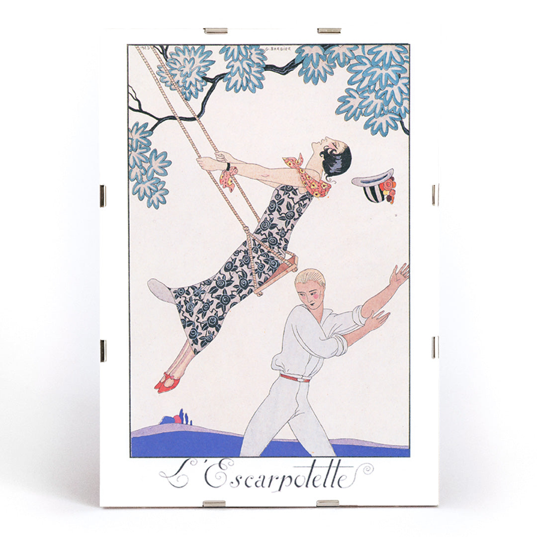 Art Deco poster of a woman on a swing with a man beneath under a tree from LEscarpotette by George Barbier, framed and displayed in modern living room decor