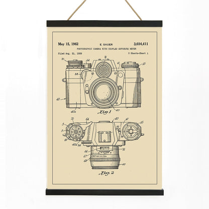 Technical illustration and poster of photographic camera with coupled exposure meter patent by E Sauer showing detailed technical drawings, with wooden magnetic frame on white background