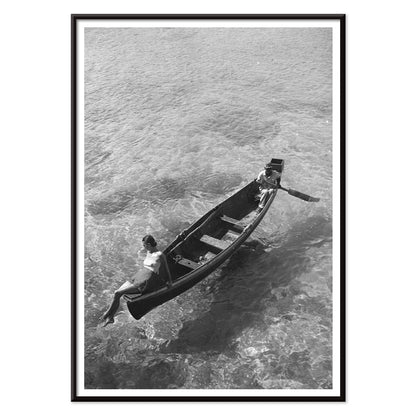 Fashion model on boat edge with man rowing in clear water Montego Bay Jamaica by Toni Frissell artwork poster, with black aluminium frame on white background