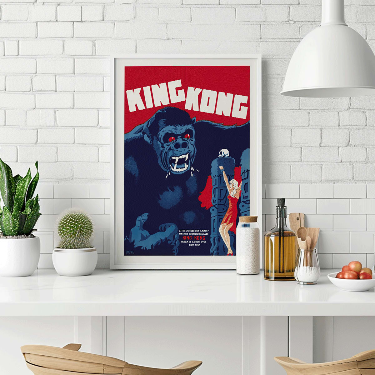 King Kong movie poster by Boye showing giant gorilla with red eyes grabbing a building and a woman in a red dress in an iconic scene, framed and displayed in modern living room decor